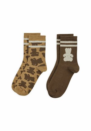 Zwei Paar Kniestrümpfe, eines braun mit einem dunklen Teddybärmuster, das andere dunkelbraun mit einem weißen Teddybär und zwei weißen Streifen am Bündchen.