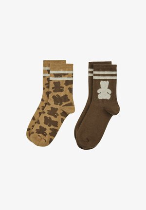 Deux paires de chaussettes montantes, l'une marron avec un motif d'ours en peluche foncé, l'autre marron foncé avec un ours en peluche blanc et deux bandes blanches au niveau du poignet.