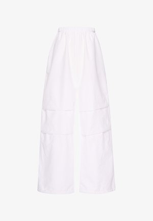 Wide-leg white pants with elastic waistband and large square pockets on the front thigh area, made from textured fabric.