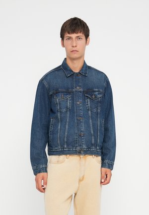Donkerblauwe denimjack met een klassieke snit, knoopsluiting, twee borstzakken en subtiele vervaging langs de naden.
