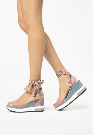 Sandalias de cuña de ante rosa con acentos de denim, cintas florales en el tobillo, punta abierta y suela de plataforma blanca. Material texturizado y colores contrastantes.