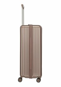 Maleta de bronce con carcasa dura y nervaduras verticales, mango telescópico extendido y cuatro ruedas giratorias sobre un fondo blanco.