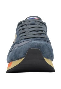 Sneaker blu in camoscio con accenti grigi, suola nera piatta e un vivace dettaglio arancione sul tallone, che mette in mostra un design classico da scarpa da corsa.