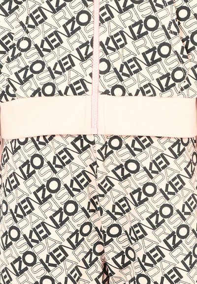 Survêtement Kenzo présentant un motif de texte noir répétitif sur un fond rose clair. Comprend une fermeture éclair sur le devant et une taille élastique.