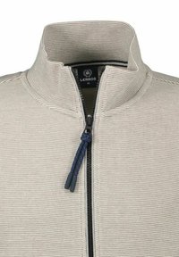 Beige zipjack met een gestructureerd breimateriaal, hoge kraag, en een marineblauwe accentrits met een lussen. Label leest "LERROS M."