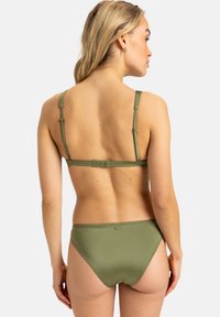 Olíva zöld bikini állítható pántokkal és kapcsos záródással. Az anyag sima tapintású, minimalista dizájnnal rendelkezik, és nincs rajta látható minta.