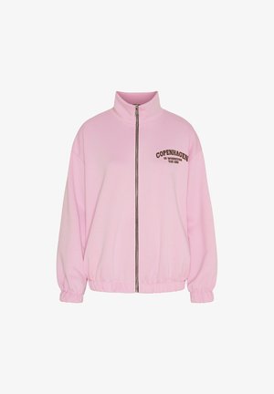 Lyserød lynlåstrøje med høj krave, elastiske manchetter og kant samt brun tekst på brystet med teksten "København er, hvor du end er."