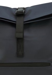 Zwarte waterdichte tas met een roll-top ontwerp, voorzien van een matte afwerking, een riemsluiting en een horizontaal ritsvak aan de voorkant.