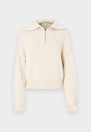 Beige kötött pulóver negyedcipzárral, texturált panellel a mellrészen, bordázott mandzsettákkal és szegélyezéssel. Rövidített fazon.