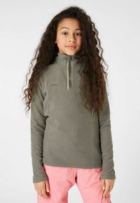 Sudadera de polar en verde oliva, con un cuello de media cremallera y mangas largas. Textura suave con un logo en el pecho. Combinada con pantalones rosa.