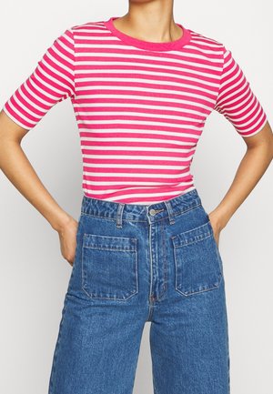 Person wearing pink and white horizontal striped short-sleeve top tucked into high-waisted blue denim jeans with front patch pockets.