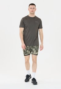 Donkergrijze sportshirt met korte mouwen, groene camouflagepatroon shorts, zwarte sportschoenen, witte sokken, staand tegen een witte achtergrond.