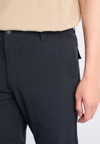 Dark grey pants made of smooth fabric with a straight cut. Features a button closure, side pockets, and subtle stitching details.