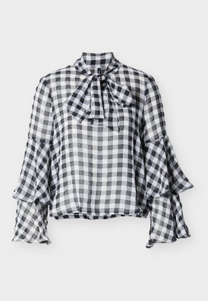 Crno-bijela bluza s karo uzorkom, visokim ovratnikom, detaljem mašne i zvonoliki rukavi. Izrađena od lagane, prozirne tkanine meke teksture.