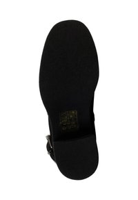 Semelle de chaussure noire avec une surface texturée, comportant des instructions d'entretien imprimées en jaune. La semelle est plate avec un bout arrondi et sans design prononcé.