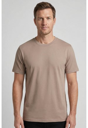 Man met kort bruin haar die een effen beige T-shirt met korte mouwen draagt, voor een lichtgrijze achtergrond, recht vooruit kijkend.