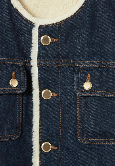 Gilet in denim con una morbida fodera in pile. Presenta bottoni a pressione in tonalità oro e cuciture arancioni. Due tasche frontali con patte.