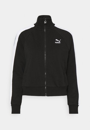 Schwarze Zip-Jacke mit hohem Kragen, weißen Seitenstreifen und Puma-Logo auf der Brust. Mit gerippten Bündchen und Saum, aus weichem Material gefertigt.