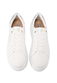Sneakers in pelle bianca con punta rotonda, suola piatta e dettagli argentati sul tallone. Lacci fissati attraverso gli occhielli; logo presente sulla linguetta.