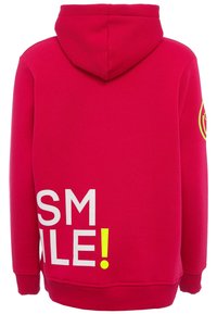 Felpa fucsia con una grande grafica testuale bianca e gialla fluorescente "SMILE!" sulla schiena, dotata di tasca a marsupio e cappuccio con cordino.