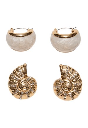 Zwei Paar Ohrringe: cremefarbene und goldene Halbmond-Creolen sowie goldene Spiral-Muscheln mit eingearbeiteten klaren Strasssteinen.