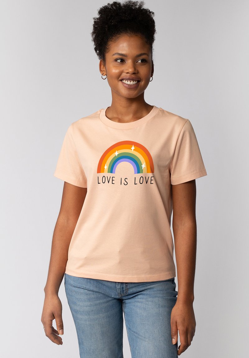 Perzik kleurige katoenen T-shirt met korte mouwen, met een regenboogafbeelding en de tekst "LOVE IS LOVE" in zwart onder het ontwerp.