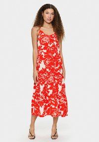Maxi kleita ar sarkanu un baltu ziedu rakstu, ar plānām siksniņām, kārtainu svārku un vieglu audumu. Brīvi pieguļ ar plūstošu siluetu.