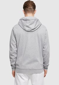 Gray hoodie with a relaxed fit, drawstring hood, and ribbed cuffs and hem. Smooth, soft fabric with a minimalistic design.