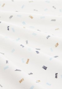 Tissu blanc avec un motif éparpillé de petits rectangles en bleu clair, bleu foncé et marron, créant un design texturé.