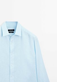 Lichtblauw overhemd met lange mouwen van linnen, met een klassieke kraag, knopen aan de voorkant en een gladde textuur. Label leest "Massimo Dutti."