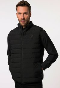 Schwarze Steppweste mit gestepptem Design, hohem Kragen und Reißverschluss. Mit subtiler Logo-Applikation auf der Brust, glatter Textur und ärmellosem Design.