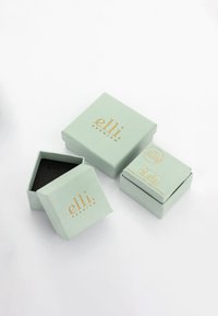 Grønne papirgaveæsker med guld prægede "elli premium" logo; inkluderer en åben æske, der afslører et sort indre og to stablede æsker.