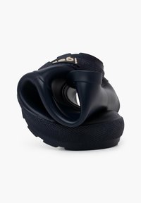 Chaussure flexible bleu marine avec une semelle texturée, au design unique et courbé, et un dessus en caoutchouc ; présente un accent de marque sur la sangle.
