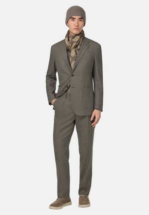 Grijze geruite outfit met notch-revers, 2-knopen sluiting en een op maat gemaakte pasvorm, gecombineerd met een beige gebreide pet en sjaal, en beige schoenen.