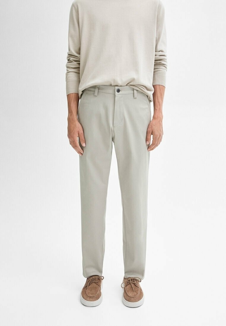 Lichtgrijze broeken van zacht stof, met een rechte pasvorm, knoopsluiting en zijzakken, gecombineerd met een lichtbeige overhemd met lange mouwen.