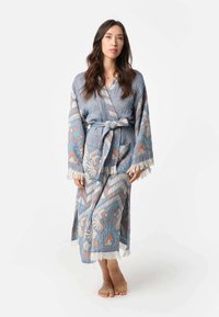 Blauwe gewatteerde robe met beige, oranje en lichtblauwe ontwerpen. Bevat een riem, zakken en franjes aan de mouwen en de onderrand.