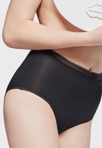 Culottes noires taille haute en matière lisse, avec une bordure en dentelle festonnée le long de la taille et un design sans coutures.