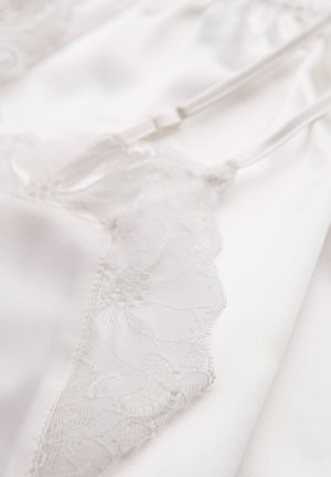 Prenda de satén blanco con delicados bordes de encaje con patrones florales, tirantes ajustables y textura suave.