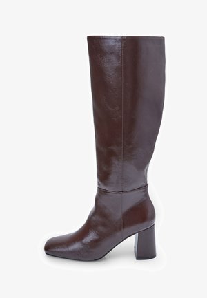 Bottes en cuir marron jusqu'au genou avec un bout carré et un talon épais. La finition est brillante, mettant en valeur la texture lisse et les lignes de design.