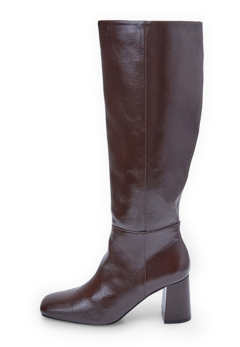 Brūni ādas augstie zābaki ar kvadrāta purngaliem un masīvu papēdi. Apdare ir spīdīga, izceļot gludo tekstūru un dizaina līnijas.