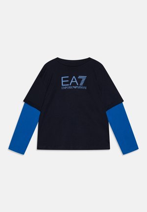 Sort og blå langærmet skjorte med teksten "EA7 Emporio Armani" og logo i lyseblåt på brystet.