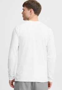 Langärmliges weißes T-Shirt aus weicher Baumwolle, mit klassischem Rundhalsausschnitt und lässiger Passform mit glatter Textur.