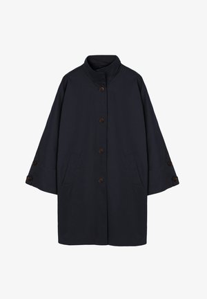 Tume sinine keskmise pikkusega mantel kõrge kraega, viie ees oleva nööbi, kahe küljetasku ja nööbitavate dekoratiivsete rihmadega laiadel varrukatel.