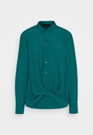 Teal langemouwen blouse met een knoopsluiting aan de voorkant en een geknoopt detail aan de onderrand, gemaakt van een soepele stof, met een klassieke kraag.