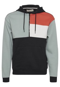 Felpa con blocchi di colore caratterizzata da un design a mezza zip. I materiali comprendono un tessuto morbido e testurizzato in nero, grigio, bianco e arancione. Include una tasca a marsupio.