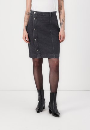 Jeanskjørt i mørk grå med frontlukking med knapper, beltehemper og rett fasong. Brukt med svarte ankelstøvler med hæl.