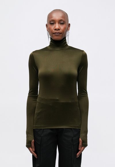 Haut à col roulé vert olive en matériau lisse et extensible ; dispose de longues manches avec des ouvertures pour les pouces et d'un design ajusté élégant.