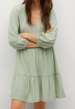 Robe verte avec un col en V, des manches longues et une jupe évasée à volants. Le tissu est texturé avec des rayures verticales.