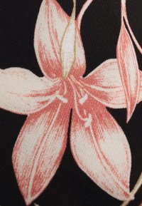 Textil med ett mönster av rosa och cremefärgade liljeblomster mot en svart bakgrund; växtdetaljerna inkluderar böjda kronblad och fina linjer.