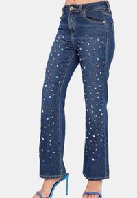 Jeans in denim con design a gamba dritta, caratterizzati da gemme e paillettes multicolori lungo la parte anteriore. Colore blu; stile classico a cinque tasche.